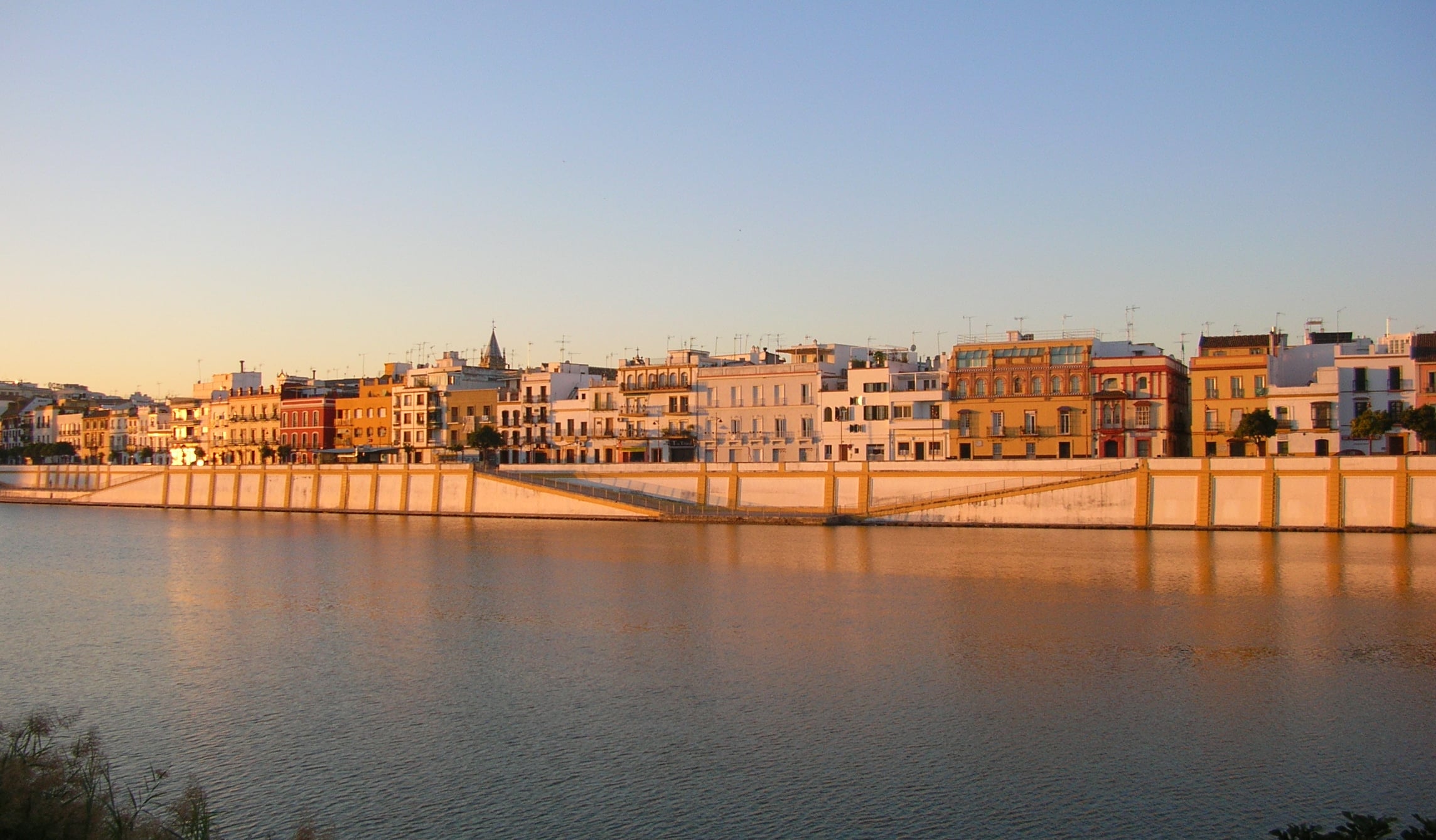 Foto de fondo de Triana en Sevilla, con un amanecer que deslumbra el puente